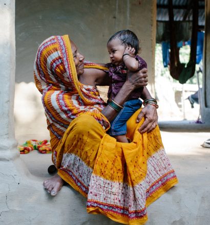 Nepalese vrouw met haar kleinkind op haar schoot