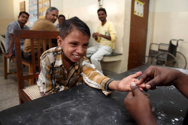 Een arts controleert de voortgang van een jongetje met lepra