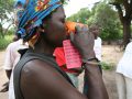 Een Mozambikaanse vrouw neemt haar medicijnen met water in            